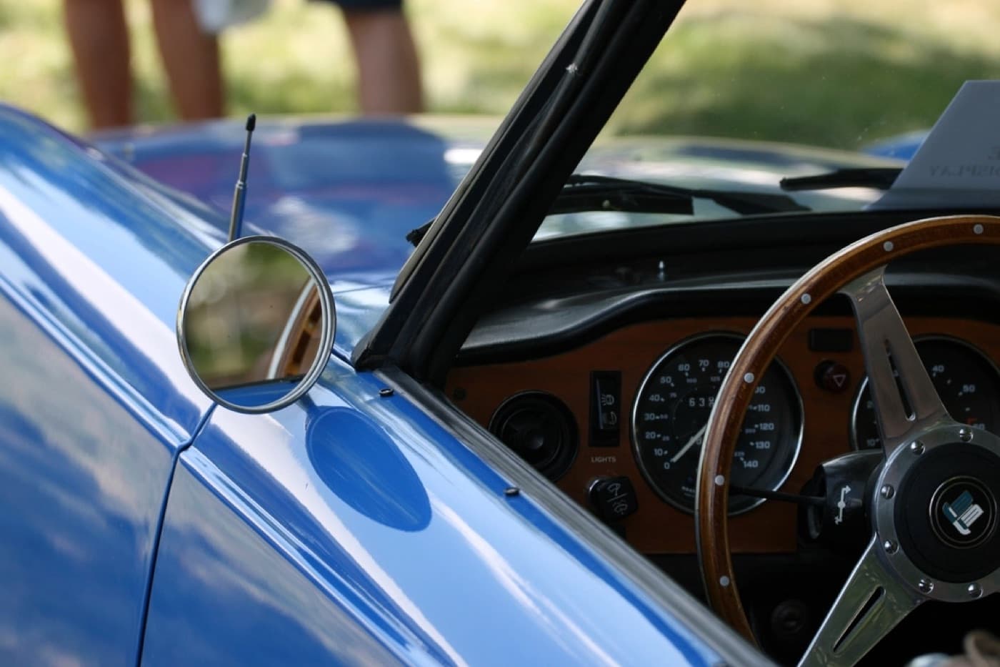 Classic car side mirror and dashboard catching warm afternoon sun